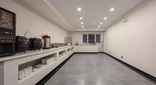 a large kitchen with white walls and a long hallway at Green Tree Inn Express Heze University Town in Zhaolou