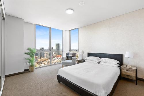 Central 2-Bed with Parking & Stunning Views في سيدني: غرفة نوم بسرير وكرسي ونوافذ كبيرة