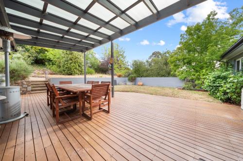 a wooden deck with a table and chairs at 4-Bed Family Home with Spacious Backyard and BBQ in Lyons