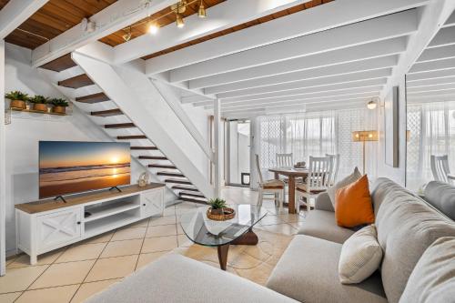 a living room with a couch and a table at Chic 2-Bed Cabin-Style Home by Mooloolaba Beach in Mooloolaba