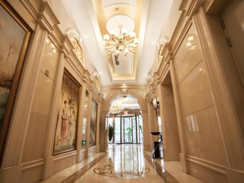 a hallway of a building with a chandelier at Vienna Hotel Hebei Tangshan Nanhu Park in Tangshan