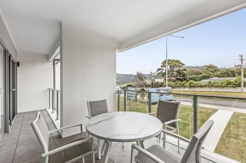 une salle à manger avec une table et des chaises sur un balcon dans l'établissement First Floor 3-Bed Stunning Unit by The Ocean, à Kiama