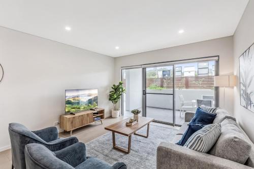 a living room with two couches and a tv at Ground Floor Spacious Home in Kiama's Heart in Kiama