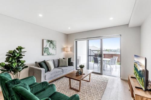 a living room with a couch and a table at Pristine 3-Bed Kiama Unit with Courtyard in Kiama