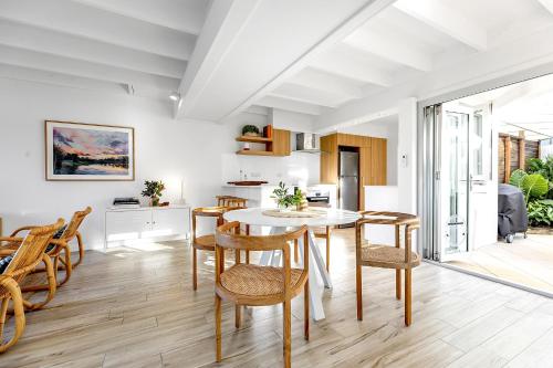 une cuisine et une salle à manger avec une table et des chaises dans l'établissement 2-Bed Coastal Haven with Pool by Sunshine Beach, à Sunshine Beach
