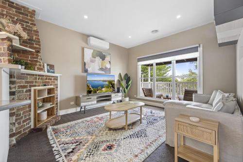 a living room with a couch and a fireplace at Lovely 3-Bed with Alfresco Dining in Prime Suburb in Ballarat
