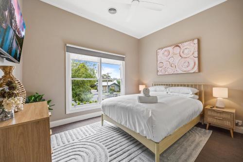 a bedroom with a large bed and a window at Lovely 3-Bed with Alfresco Dining in Prime Suburb in Ballarat
