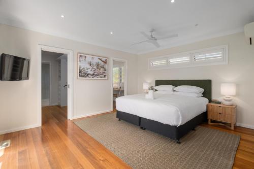 Un dormitorio con una cama y un televisor de pantalla plana. en Luxurious 3-Bed Home with Outdoor Spa by Beach, en Tootgarook