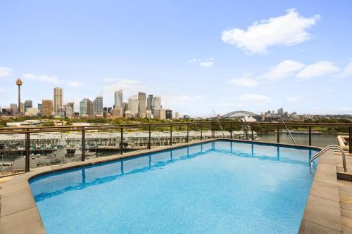a swimming pool with a view of the city at Cosy 1-Bed with Swimming Pool Facing Opera House in Sydney