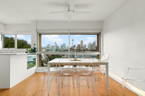 a dining room with a table and chairs and a window at Cosy 1-Bed with Swimming Pool Facing Opera House in Sydney