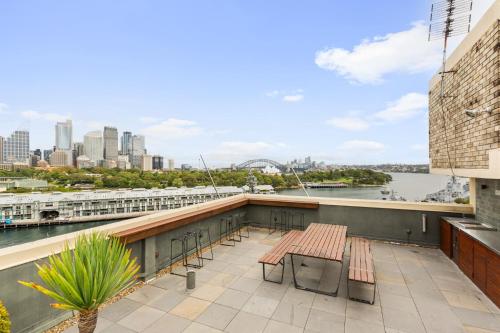a balcony with benches and a view of the city at Cosy 1-Bed with Swimming Pool Facing Opera House in Sydney
