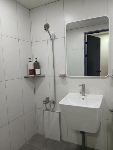 un bagno bianco con lavandino e specchio di SRR Stay a Gwangmyeong