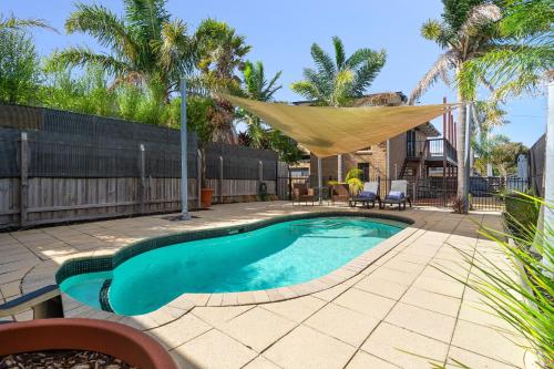 a swimming pool with a hammock in a backyard at Spacious 4-Bed Home 5-min from the Beach in Capel Sound