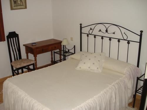 a bedroom with a bed and a table and a desk at Casa Nueva Carmen in Pendueles