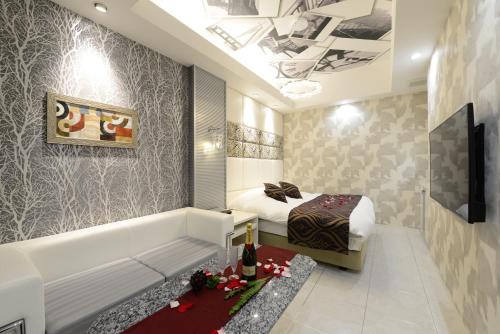 a bedroom with a bed and a bathtub and a bed and a tub at Hotel S-CUBE (Adult Only) in Bando