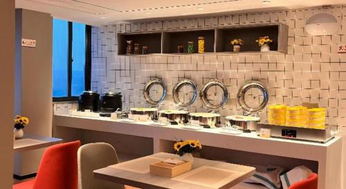 La salle de bains est pourvue d'un comptoir avec des lavabos et des miroirs. dans l'établissement Borrman Hotel Wuhan Yellow Crane Tower Fuxing Road Metro Station, à Wuhan