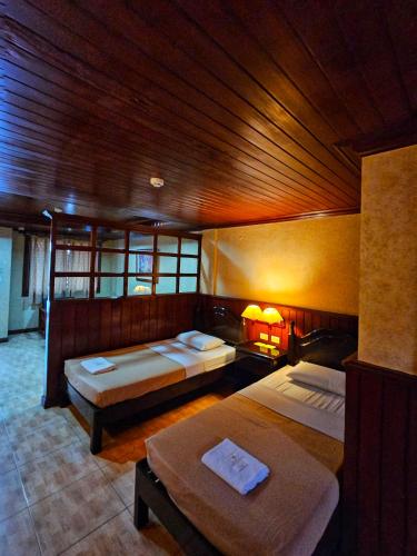 a bedroom with two beds and a wooden ceiling at Ciello Accommodation 3 in Nabalean