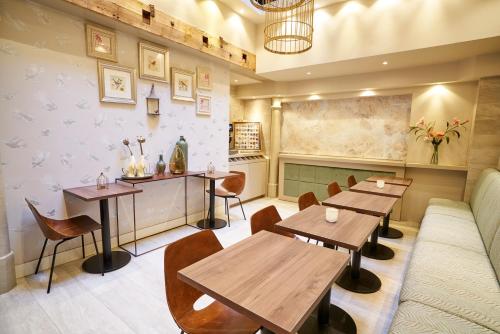 une salle à manger avec des tables et des chaises en bois dans l'établissement Hotel The Bird, à Amsterdam