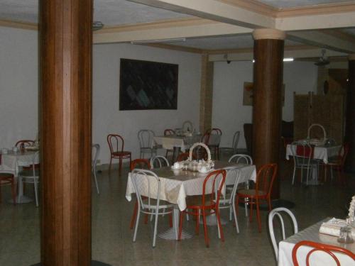 a dining room with white tables and red chairs at Tudor Water Sports Hotel in Mombasa