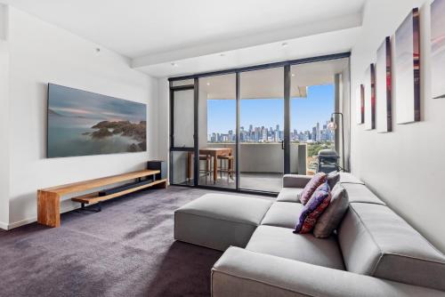a living room with a couch and views of the city at 2-Bed, 500m From The Beach with Pool, Gym & Sauna in Melbourne