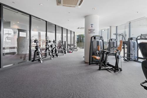 a gym with a row of bikes and treadmills at 2-Bed, 500m From The Beach with Pool, Gym & Sauna in Melbourne