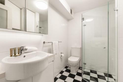 a white bathroom with a sink and a toilet at Inner-West Studio in a Perfect Location in Sydney