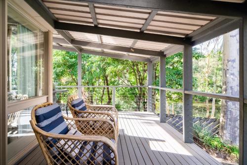 un porche avec deux chaises en osier et un auvent dans l'établissement Secluded 3-Bed Retreat Moments to the Beach, à Surf Beach