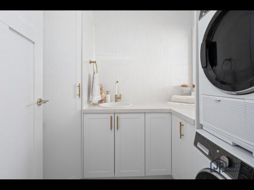 a white bathroom with a sink and a microwave at Elegant Beachside Retreat with Luxurious Amenities in Tomakin