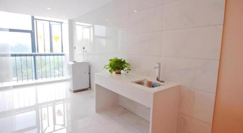 ein weißes Badezimmer mit Waschbecken und Fenster in der Unterkunft Green Tree Inn Jiangsu Changshu Southeast Yuyue Square in Gujiashuigou