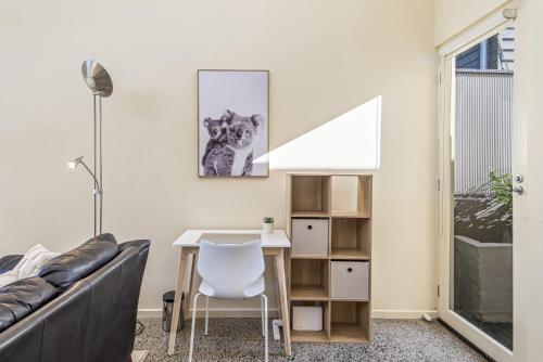 a living room with a desk and a dog picture on the wall at Gorgeous 2-Bed Victorian Home in Artsy Suburb in Melbourne