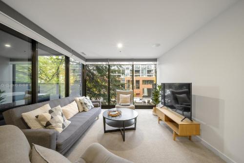 a living room with a couch and a fireplace at Chic Inner-City 2-Bed Abode with Pool Gym & Sauna in Canberra