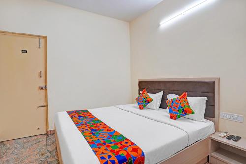 une chambre avec un grand lit blanc avec des oreillers colorés dans l'établissement FabHotel Platinum - Shivaji Nagar, Commercial Street, à Bangalore