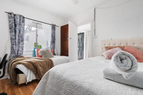 墨尔本Melbourne Beach guests house 2km CBD的一间带两张床和一扇窗户的白色卧室