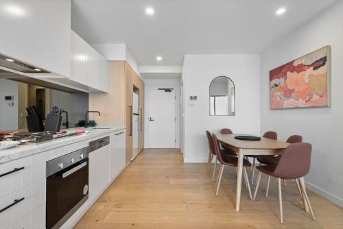 Una cocina y un comedor con mesa y sillas. en Contemporary 2-Bed Haven with Swimming Pool, en Clayton North