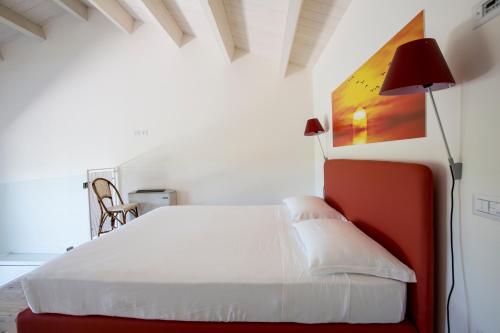 a bedroom with a white bed and a lamp at Il Portico in Fano