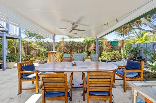 a patio with a wooden table and chairs at The Little Blue Shack - Quaint Granny Flat in Bli Bli