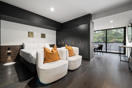 TurnerにあるImmaculate Braddon Studio with Accessible Bathroomの大きなベッドと椅子2脚のある寝室