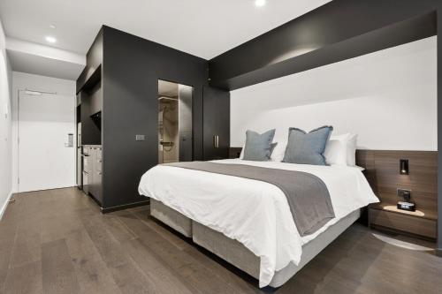 a bedroom with a large bed with black walls at Braddon Studio with Parking & BBQ in Canberra