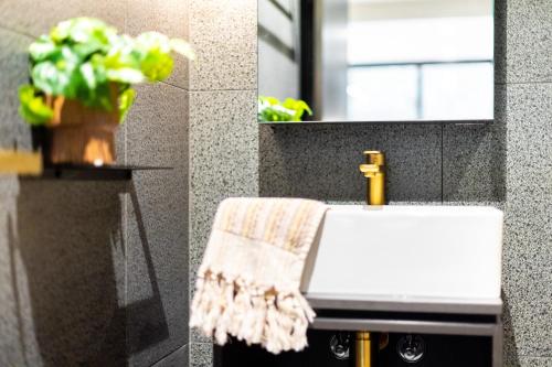 a bathroom with a sink and a towel on a counter at Braddon Studio with Parking & BBQ in Canberra