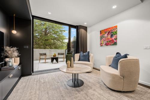 a living room with two chairs and a table at Braddon Studio with Parking & BBQ in Canberra