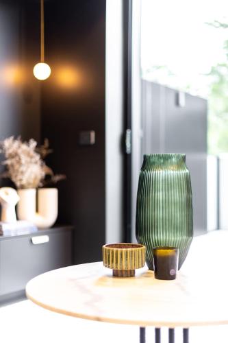 a green vase sitting on top of a table at Braddon Studio with Parking & BBQ in Canberra