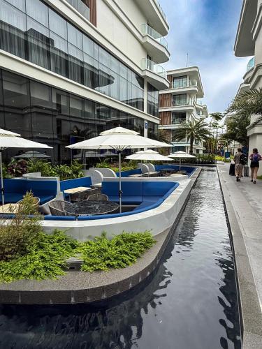 a row of tables and umbrellas next to a building at Sunshine Layan Beach Resort 2 bedroom #84192 in Layan Beach