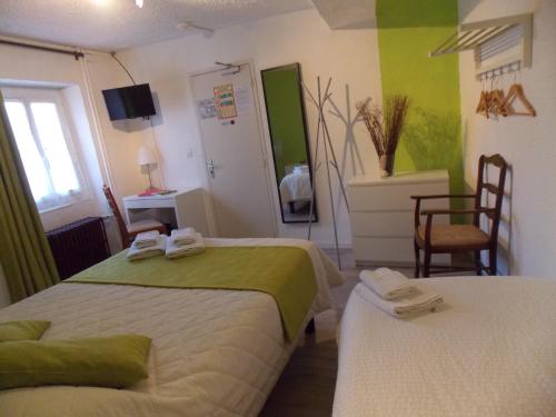 a hotel room with two beds and a television at Hôtel Le Chambellan in Dijon