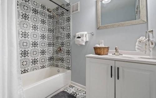 a bathroom with a tub and a sink and a mirror at *Super close to Hospitals|UAB|Open fl plan|2 bdr in Birmingham