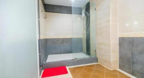 a shower with a glass door in a bathroom at Huandalha Resort in Ban San Pa Sak