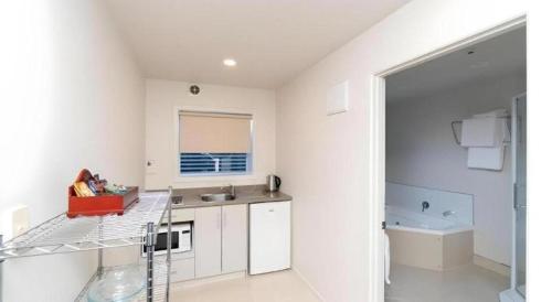 une cuisine blanche avec un comptoir et un évier dans l'établissement Hawera Central Motor Lodge, à Hawera