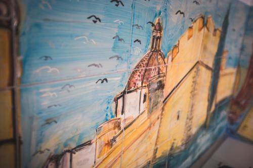 a painting of a building with birds in the sky at B&B Le Ferule in Manfredonia