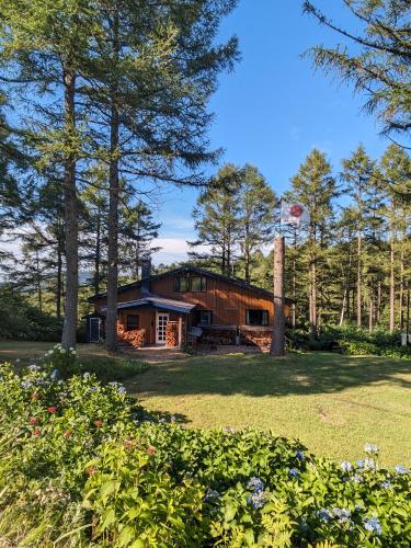 a house in the middle of a yard with trees at Japan Snowsports in Iiyama