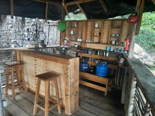 MorogoroにあるOlimpos campingの木製のカウンターとスツールを備えた屋外キッチン
