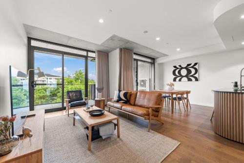 a living room with a couch and a table at Stylish 2-Bed in Braddon with Alfresco Dining in Canberra